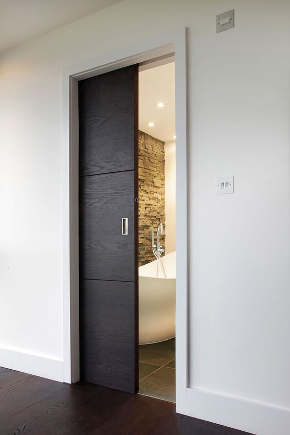a small dark-stained pocket doors leads to the bathroom and makes it look like a treasure