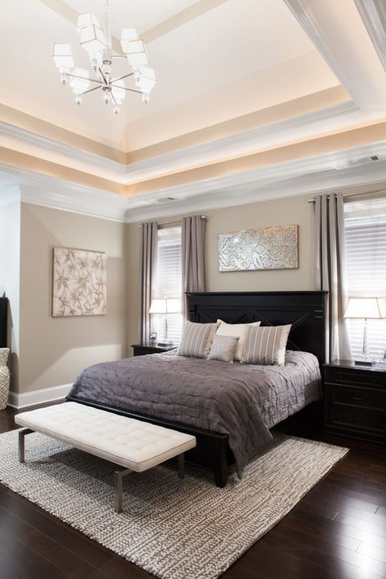 a sophisticated greige bedroom with black furniture, a white upholstered bed, bold artworks and a double height ceiling is amazing