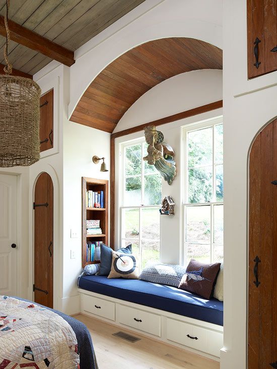 a traditional windowsill reading space with an upholstered bench with drawers and built-in stained bookshelves