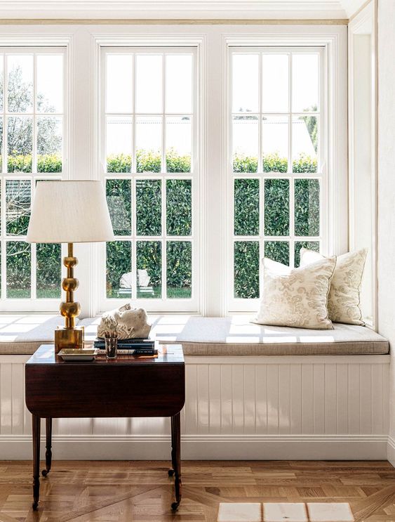 a welcoming nook - French windows and a windowsill daybed plus a dark stained coffee table for placing books and drinks