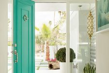 a white entrance accented with a bold green front door and gold touches are perfect for a mid-century modern house