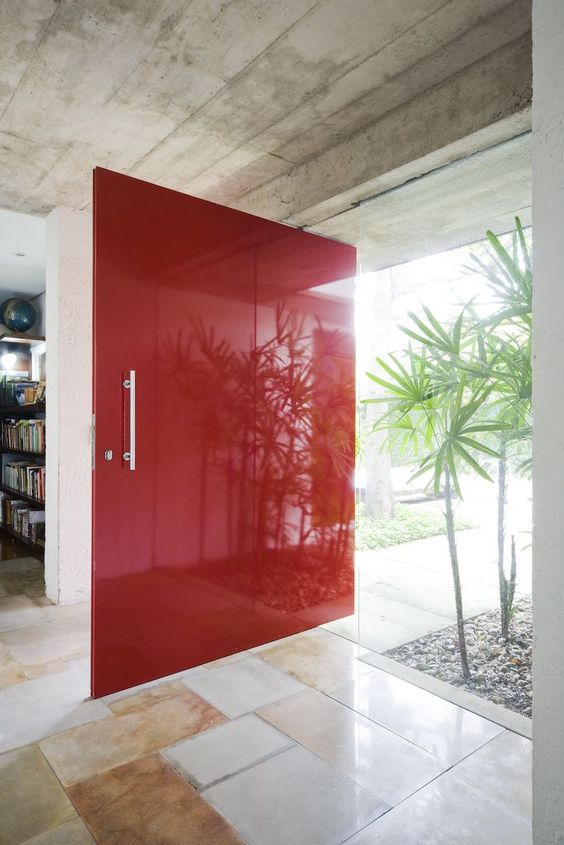 an oversized bold red super sleek front door with a usual handle is a fantastic idea for a mid-century modern home