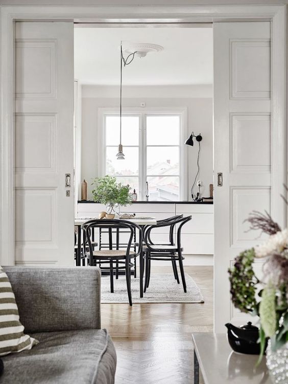 elegant white paned pocket doors are ideal for a Scandinavian space and they don't waste any room