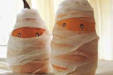 fun gourds styled as mummies with googly eyes are a cool craft for a kids’ Halloween party and you cna make them together