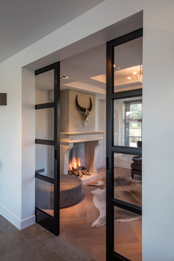 lovely black frame pocket doors separate the rooms and do that with style without looking heavy