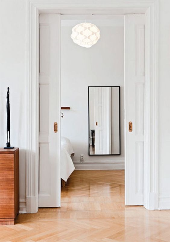 refined white paned pocket doors are a perfect way to divide the spaces in a stylish way and save a lot of room