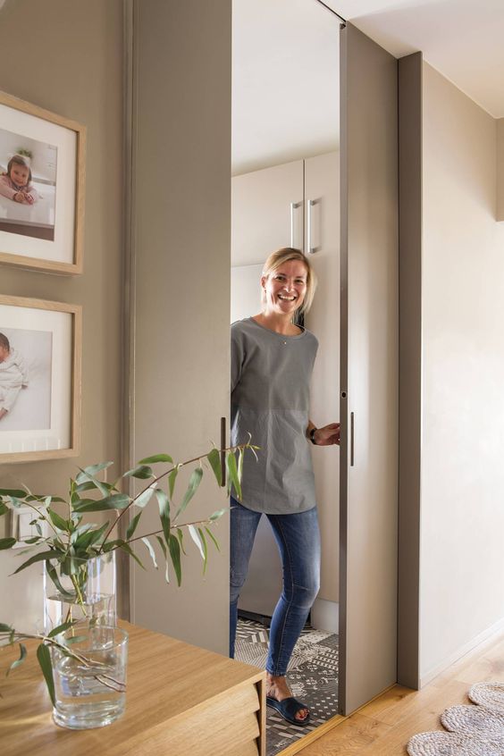sleek and chic dove grey pocket doors wiht little handles are ideal to delicately separate the spaces without stealing room