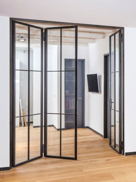 spaces separate with black metal frame and glass folding doors have more light in and such doors look more stylish and cool