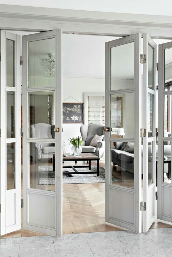 whitewashed wood and glass folding doors separate the spaces very well and match the farmhouse decor of the space