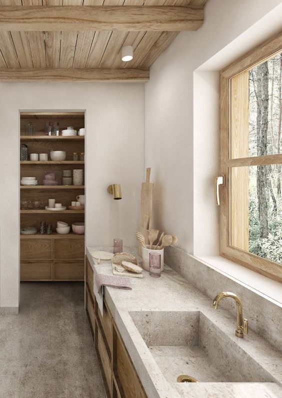 a gorgeous neutral kitchen with light-stained cabientry, stone countertops and a sink, a wooden ceiling and a small pantry