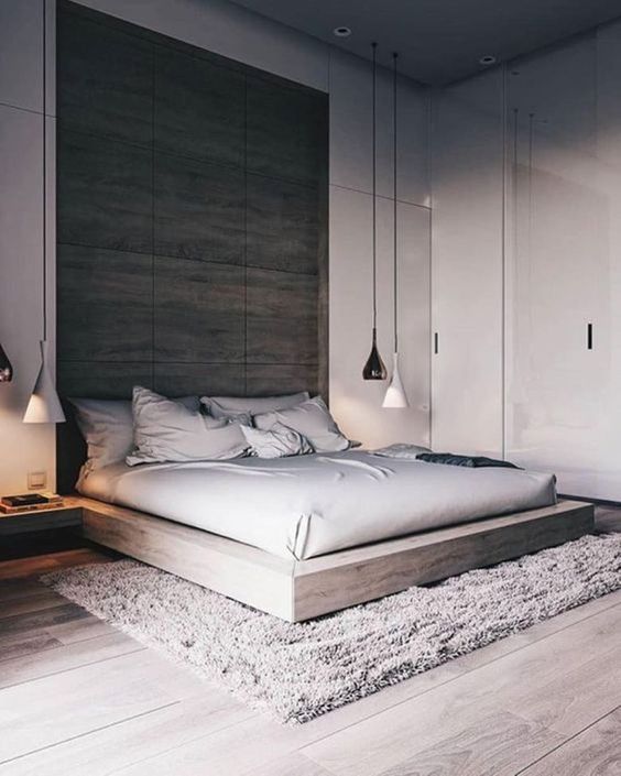 a gorgeous neutral bedroom in minimalist style, with a double-height ceiling, an extended headboard, a platform bed and pendant lamps
