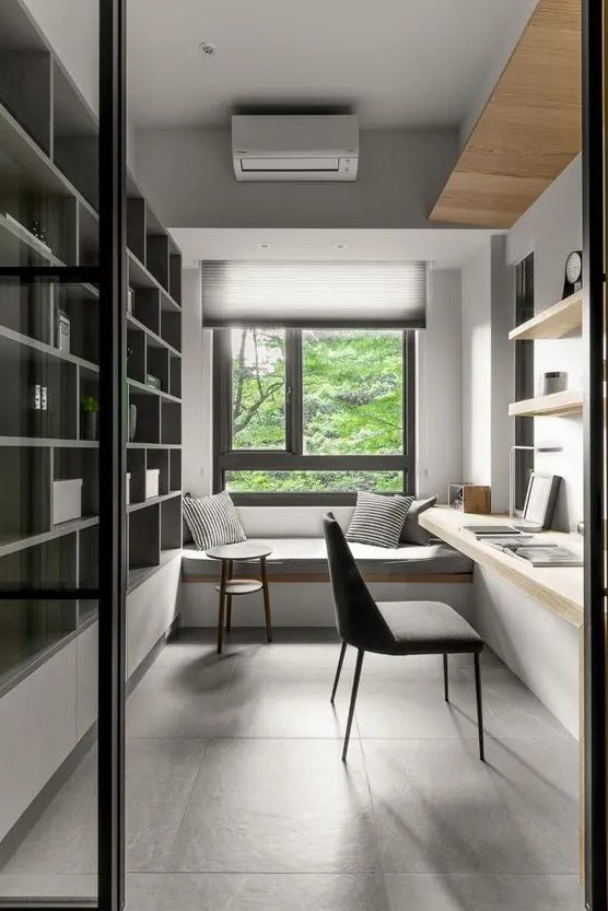 a minimalist home office with a built-in storage unit, a built-in desk and shelves, a windowsill daybed and pillows