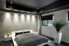 a bachelor bedroom with a black ceiling, a white floating bed and nightstands, black and grey bedding