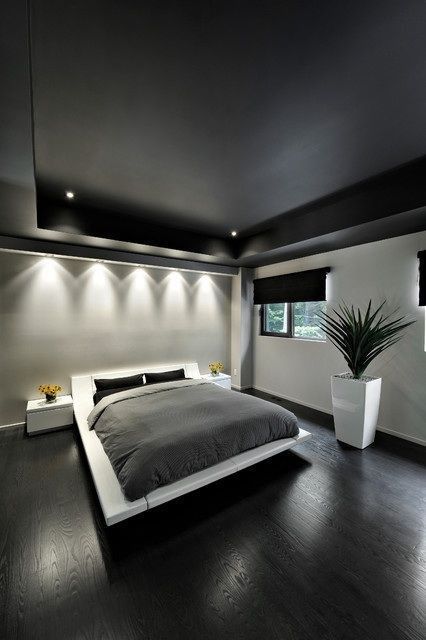 a bachelor bedroom with a black ceiling, a white floating bed and nightstands, black and grey bedding