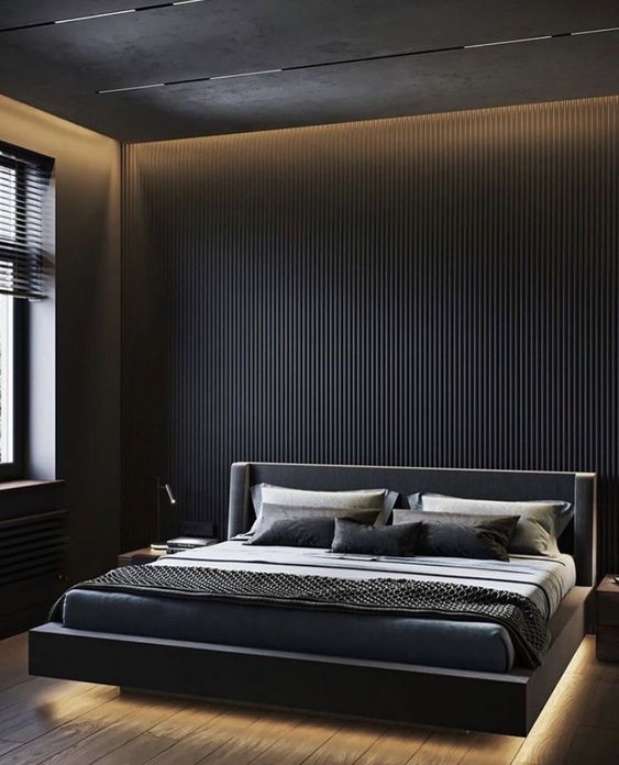 a black minimalist bedroom with a black wooden slab accent wall and built-in lights, a black floating bed with lights and monochromatic bedding