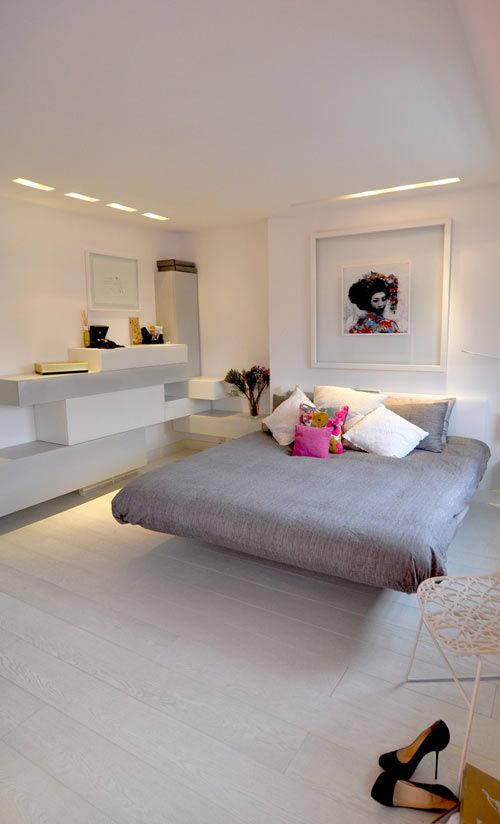 a catchy minimalist bedroom with a sleek floating storage unit, a floating bed, some Japanese art and a woven chair