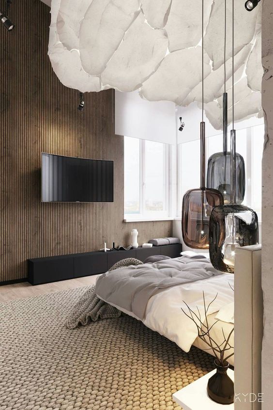 a fab contemporary bedroom with a wooden slab accent wall, a white floating bed with neutral bedding, a cluster of dark glass pendant lamps and a black TV unit