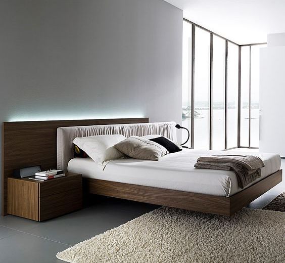 a laconic contemproary bedroom with a glazed wall, a stained floating bed with a lit up headboard and nightstands is a chic space