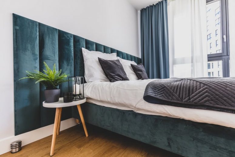 a welcoming bedroom with a teal floating bed and a soft headboard plus matching curtains is a gorgeous space to sleep