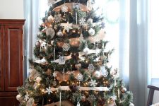 05 a beautiful Christmas tree with lots of white mismatching snowflakes, white and silver onrmanets, pincones and burlap ribbons plus lights will do for a rustic or woodland celebration