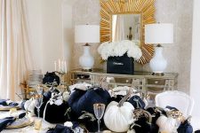 06 a glam Thanksgiving tablescape with large black and white velvet pumpkins, gold chargers, cutlery and candleholders plus black napkins