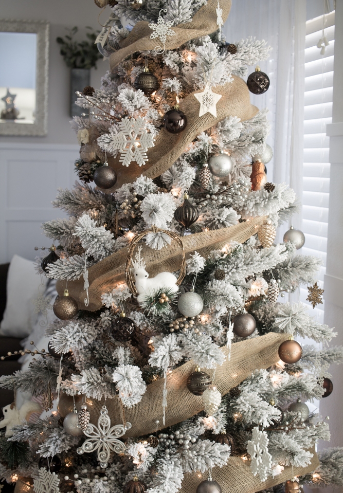 a beautiful winter Christmas tree with burlap ribbons, silver, grey and gold ornaments, deer, white snowflakes and lights
