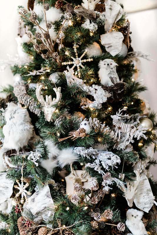 a winter woodland Christmas tree with pinecones, owls, wooden snowflakes, deer heads, lights and faux fur is amazing