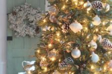 16 a pretty and simple forest Christmas tree with lights, gold and white ornaments, snowy pinecones is an amazing decoration you can realize yourself