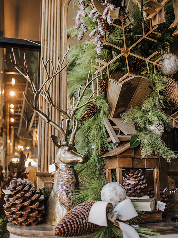 a gorgeous  woodland Christmas tree all covered with pinecones, wooden snowflakes, a wooden candleholder and lots of large pinecones around