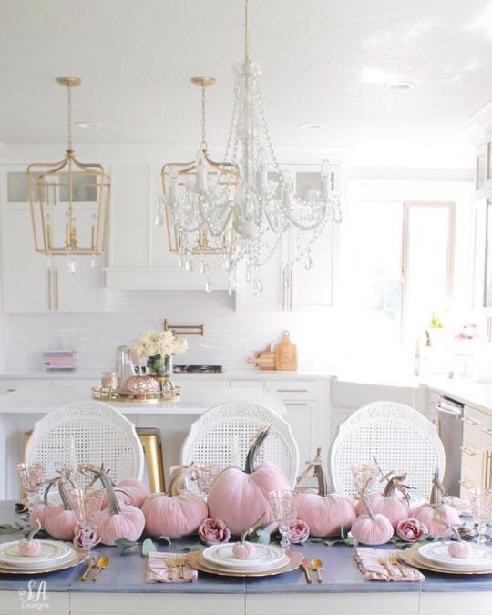 a super glam Thanksgiving tablescape with pink vlevet pumpkins and pink peonies, gold chargers and cutlery and mini pumpkins on each place setting