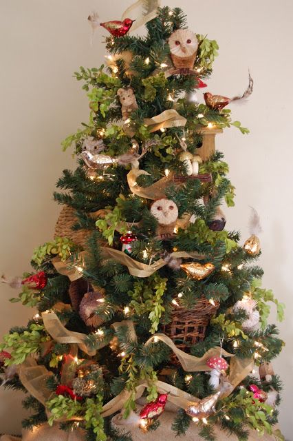 a fun woodland Christmas tree with owls, bird ornaments, lights, mushrooms, acorns, garlands and green branches is a very cool and unusual idea