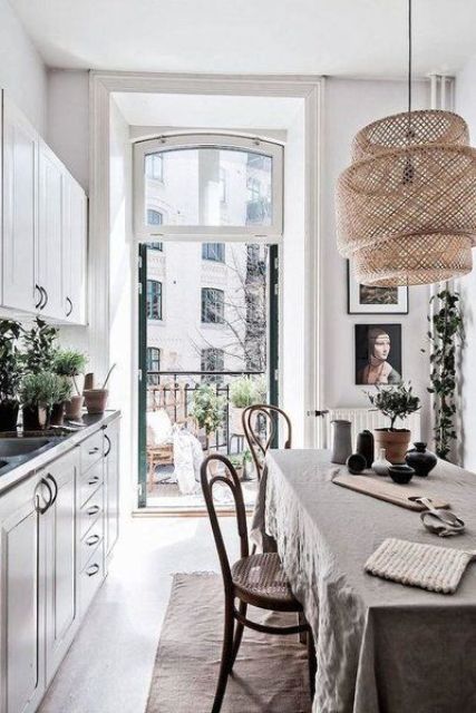 a Scandinavian kitchen with a dining space, with crown molding used to frame the doorway, with simple and vintage rustic furniture