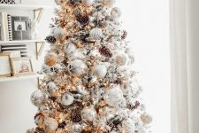 a breathtaking winter wonderland Christmas tree with white and silver ornaments, lights, pinecones and branches is a gorgeous idea