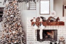a fabulous winter wonderland Christmas space with oversized pinecones, white stockings, a flocked Christmas tree with lights and pinecones and a toy deer