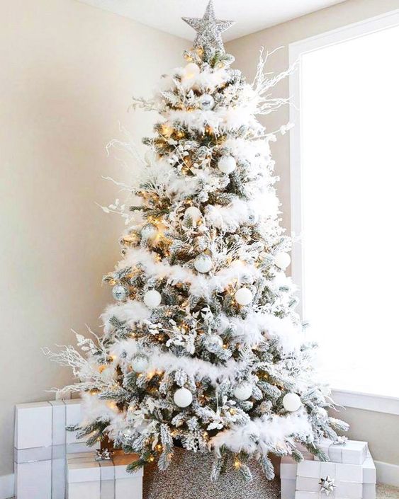 a fabulous winter wonderland Christmas tree with white garlands, branches, silver and white ornaments, lights and a silver star topper is wow