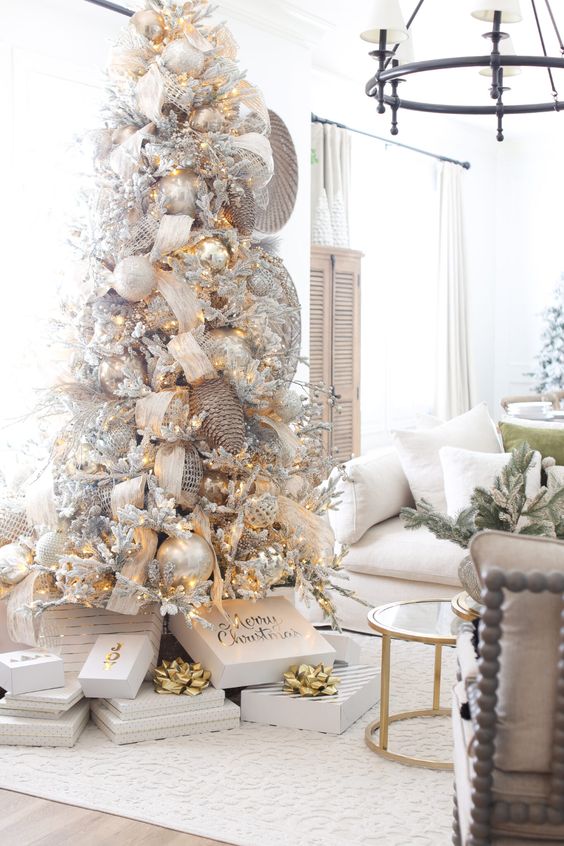 a fantastic winter wonderland Christmas tree with silver and pearl ornaments, lights, snowy berries and branches, oversized pinecones