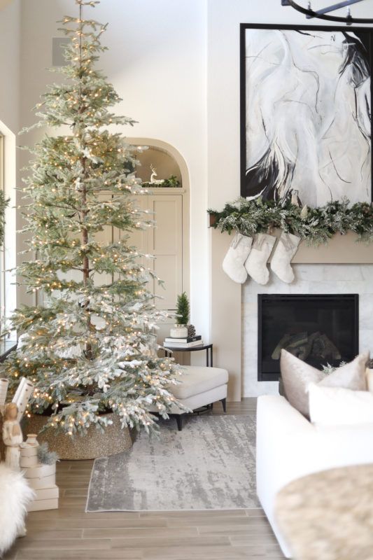 a flocked Christmas tree with lights, an evergreen garland and white stockings will finish off your neutral interior turning it into a fairy-tale