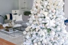 a flocked Christmas tree with pastel and metallic ornaments, white fabric ribbons and fabric blooms is a very fairy-tale like idea