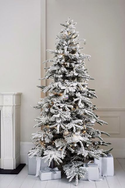 a glam winter wonderland flocked Christmas tree with silver ornaments and lights and no other decor looks very tasteful and chic