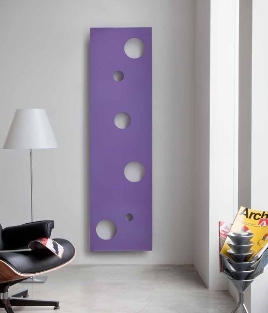 a modern space with an elegant black leather chair and a playful lilac pola dot radiator on the wall for a touch of color and fun