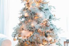 a very snowy Christmas tree with white fluffy garlands, lights, white, silver and gold ornaments, antlers is idea for a winter wonderland space