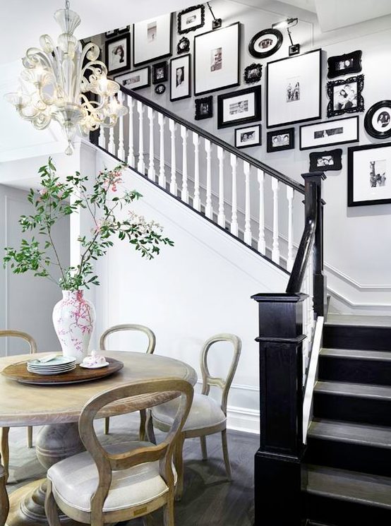 a vintage gallery wall with mismatching refined and modern black frames adds elegant and chic feel to the space