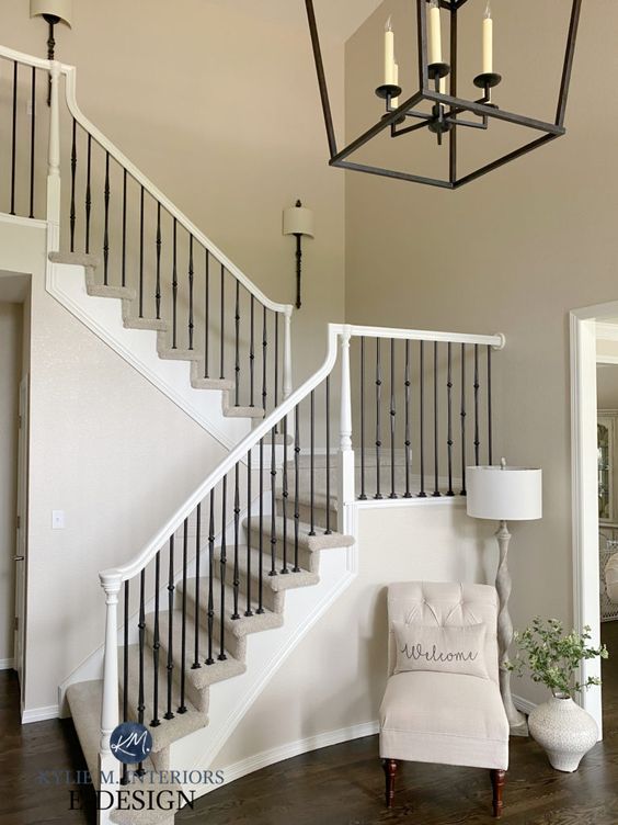 an elegant and chic greige entryway with a white vintage chair and a floor lamp, some greenery plus a pendant lantern