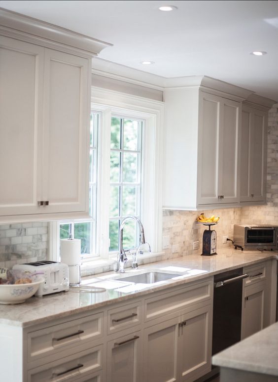 crown molding that matches the cabinets in color makes the space look higher than it is and is a cool solution