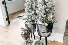 winter wonderland Christmas decor – potted flocked trees with lights, gift boxes with pinecones and a faux owl is amazing