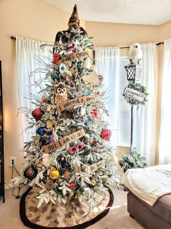 a creative and bright flocked Christmas tree with bold ornaments, letter garlands, a Sorting Hat topper, owls, branches and pinecones