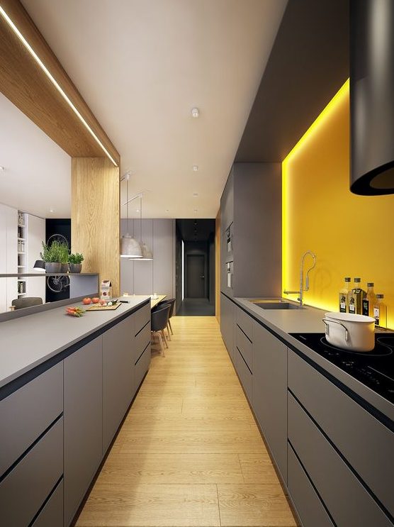 a bold minimalist kitchen with sleek grey cabinetry and a sunny yellow lit up backsplash for a bright look