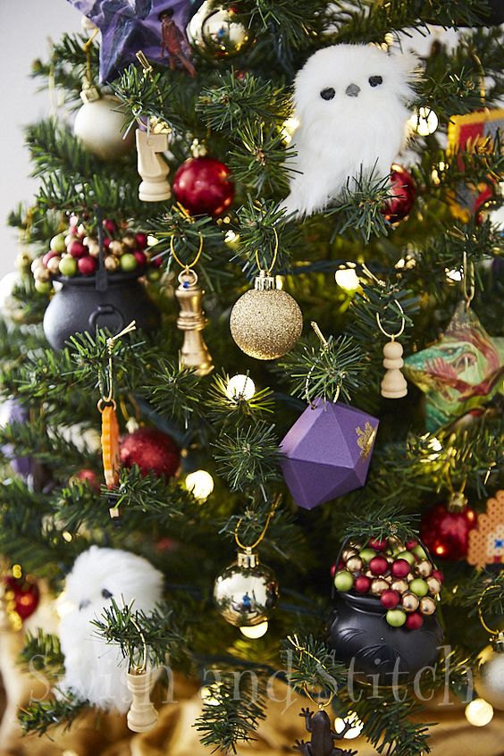 a bright Harry Potter Christmas tree decorated with faceted purple ornaments, cauldrons, chess, owls, lights and other stuff is wow