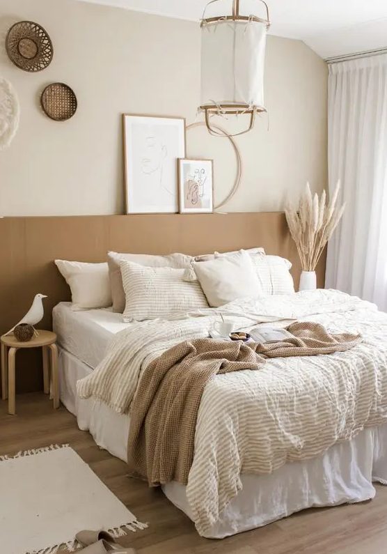 a neutral boho bedroom with a terracotta accent, a pendant lamp, woven baskets, layered bedding