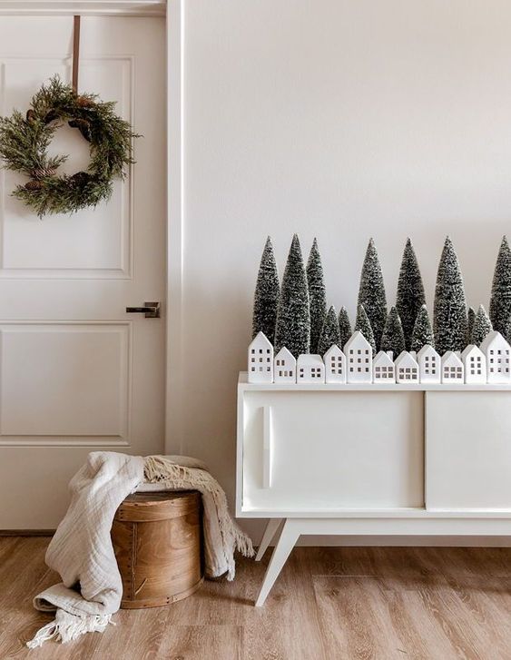 a chic credenza with bottle brush trees and small white houses for Scandinavian Christmas decor